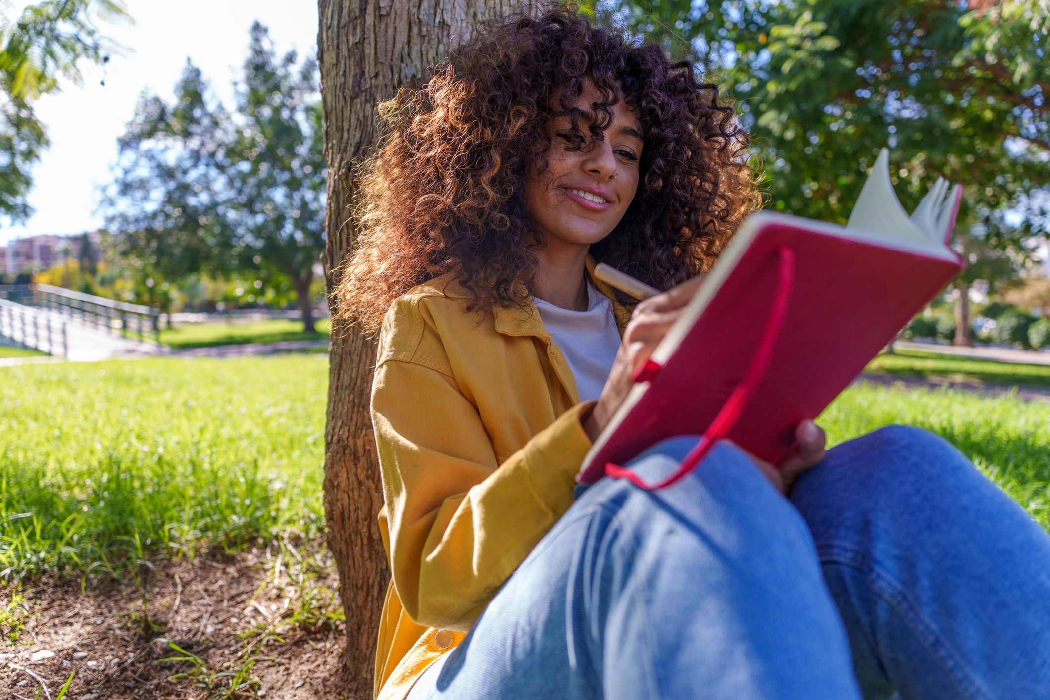 Woman journaling outdoors in a reflective moment