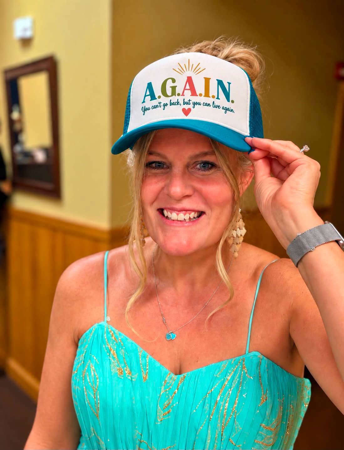 Michelle Bader Ebersole smiling in an A.G.A.I.N. cap